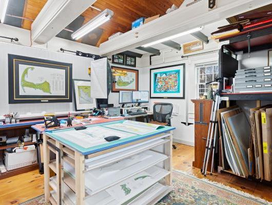 Office with wood ceiling and tray table and maps hanging on the wall